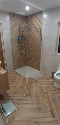 Herring bone timber effect floor and shower tiles,  shower, toilet and vanity unit in a Sligo home installed by North West Tiles & Timber, Ireland